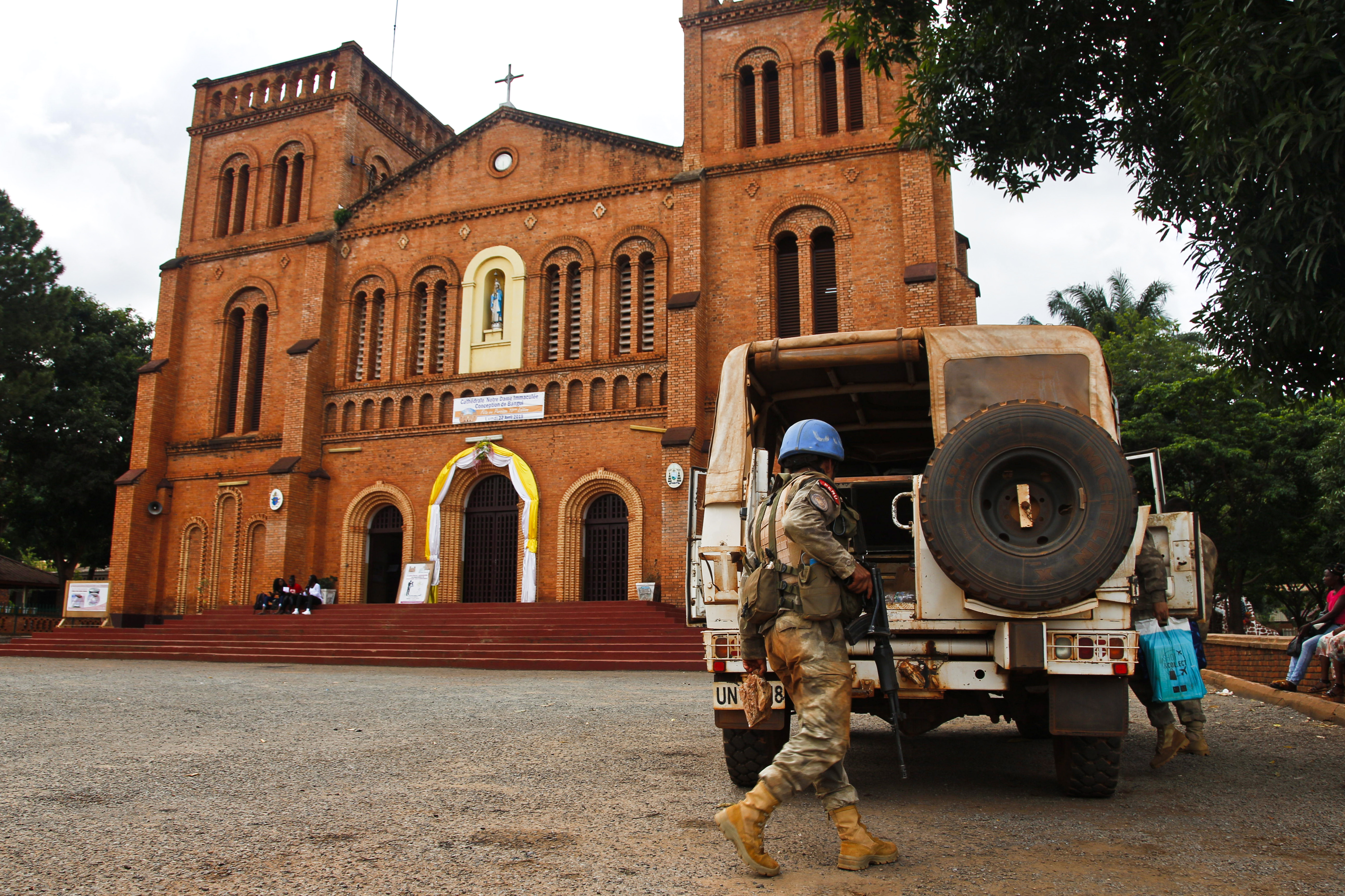 Un miembro del personal de mantenimiento de la paz de las Naciones Unidas carga una camioneta de las Naciones Unidas frente a la catedral de Bangui, República Centroafricana