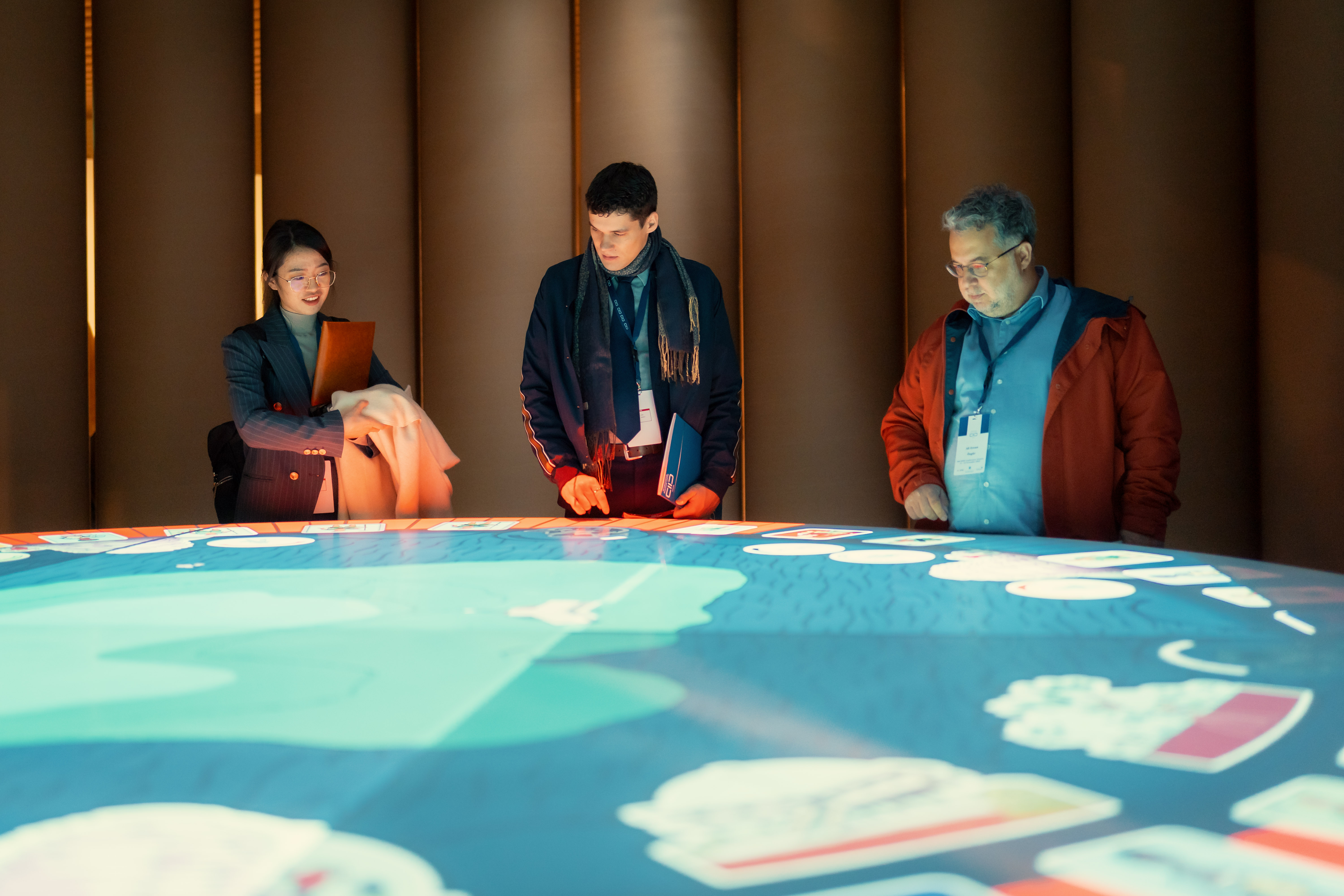 Three people looking at a map at an exhibition. 
