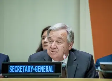 UN Secretary General Guterres sits at table 