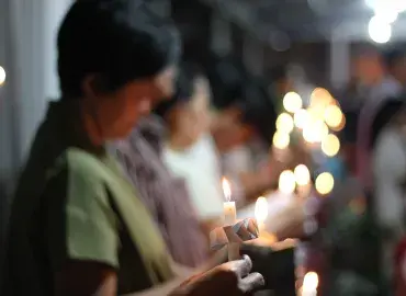 Women hold candles at a worship service in Indonesia 