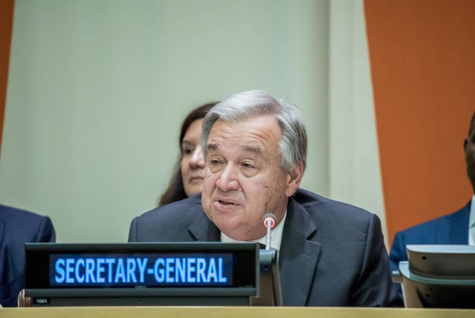 UN Secretary General Guterres sits at table 