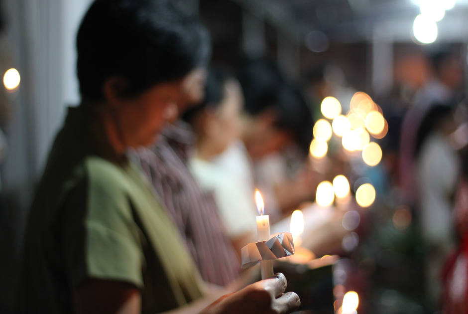 Women hold candles at a worship service in Indonesia 