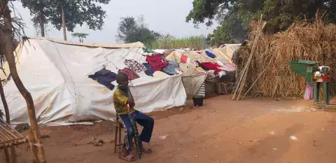 A bold push for peace: Man sits in front of tents in camp in Central African Republic 