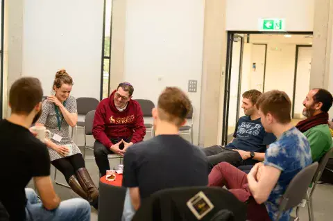 KAICIID Fellow Alex Goldberg sits with a group of students and staff at the University of Surrey in the UK