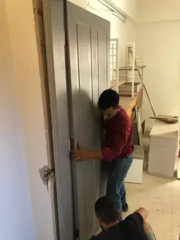 Two men from the KAICIID Be Beirut project install a door