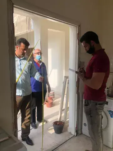 Three men from the KAICIID Be Beirut project measure a space for a door