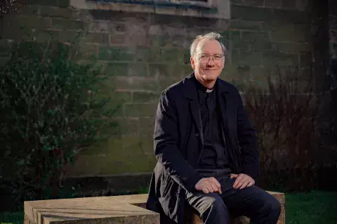 Rev. Dr. Sudworth sits outside of the All Saints Parish Church in Kings Heath, Birmingham, UK. Photo: Khalid Bari