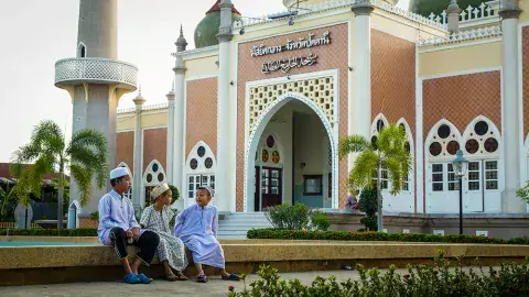 Young muslims sit together after prayer in front of the Central Mosque of Pattani in southern Thailand. Photo: noonsony77