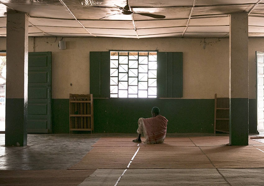 A man sits alone, enveloped in the stillness of the Central Mosque located in PK5. Photo: Kaleb Warnock/KAICIID