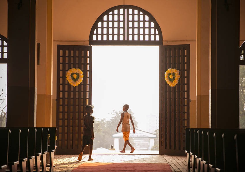 Two boys pass through the main doors the Cathédrale Notre-Dame of Bangui. Photo: Kaleb Warnock/KAICIID