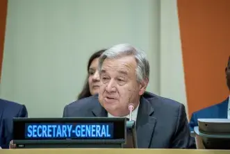 UN Secretary General Guterres sits at table 