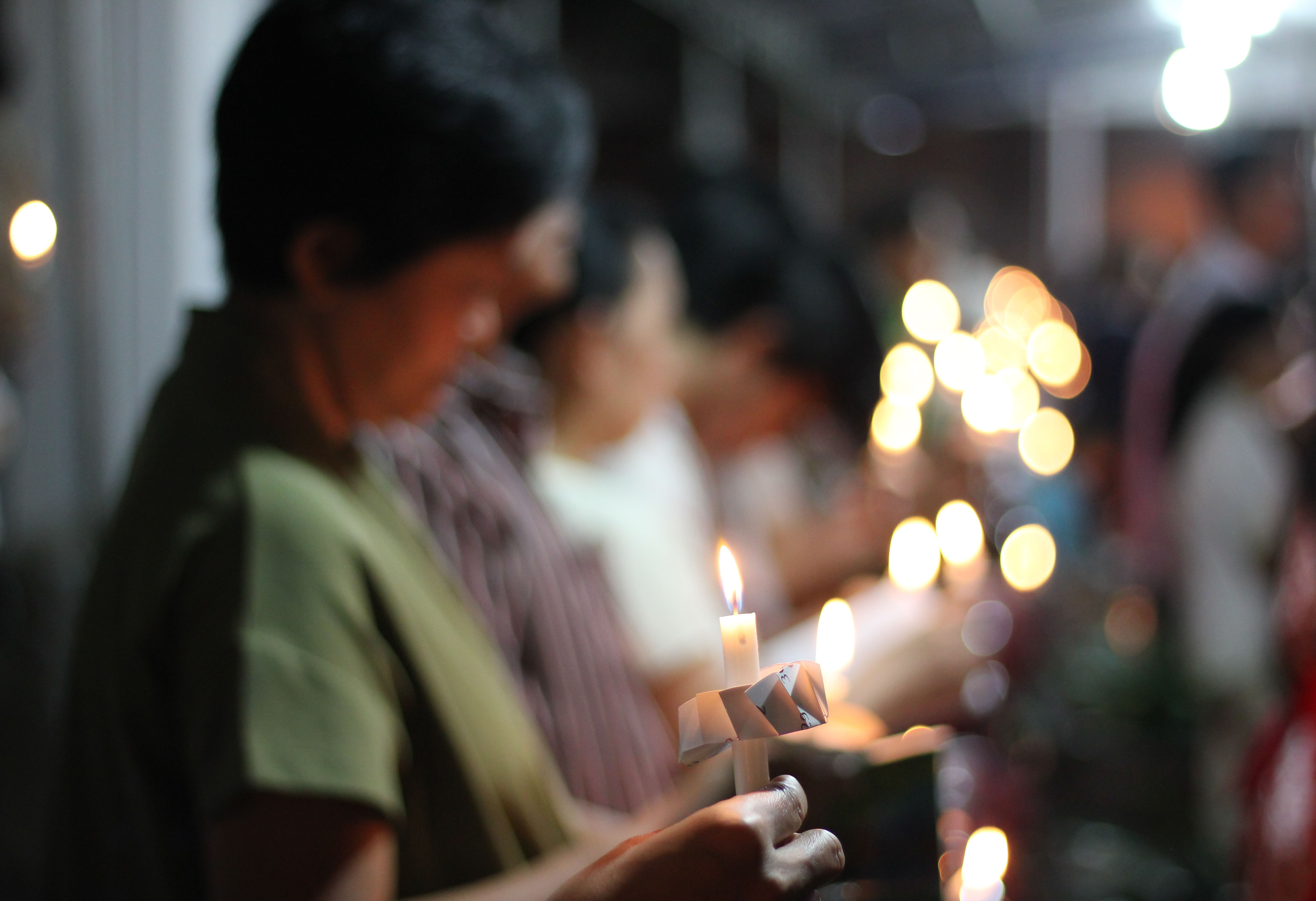 Women hold candles at a worship service in Indonesia 